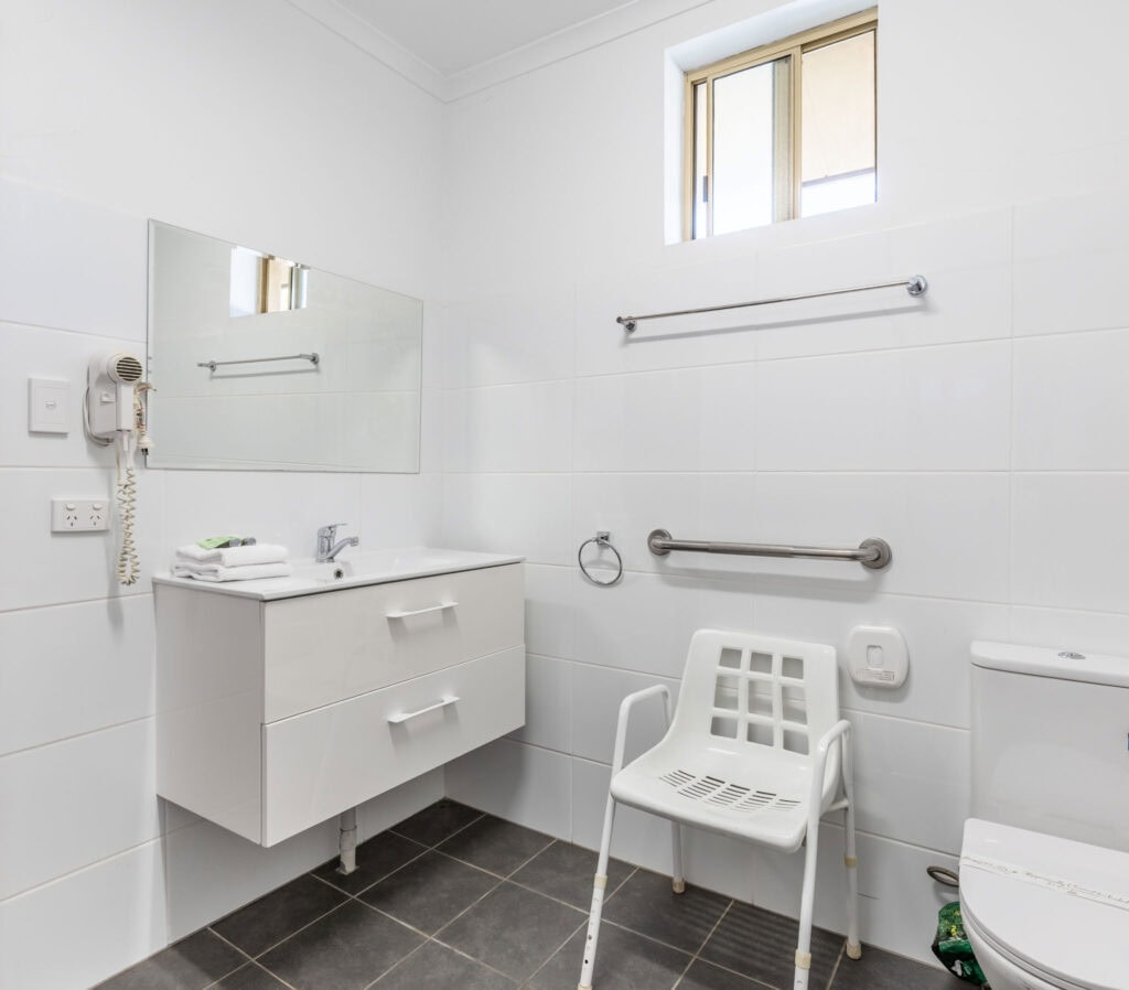 accessible ensuite bathroom vanity and shower chair